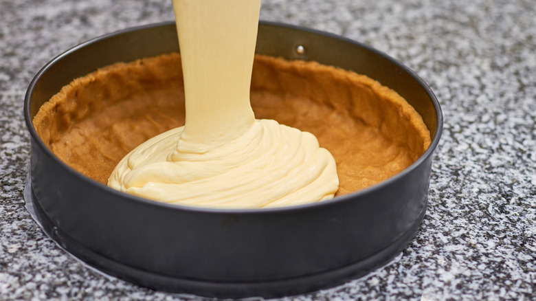 Cheesecake filling being poured into crust