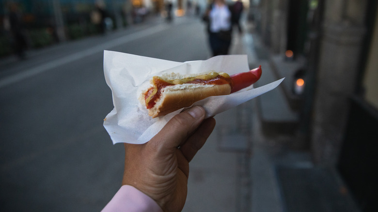 Danish hot dog held by a hand