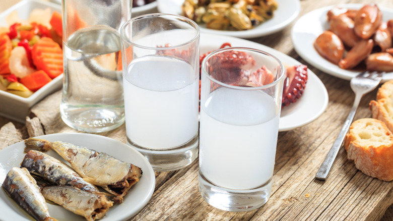 Glasses of ouzo with food