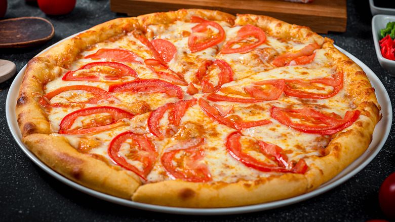 Pizza with tomato slices.
