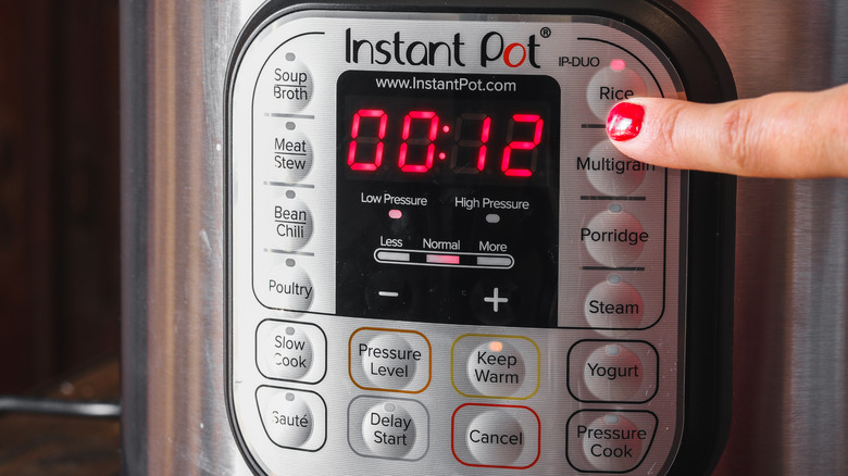Someone setting the rice function on the control panel of an Instant Pot
