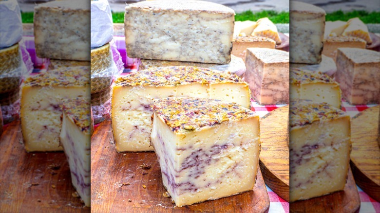 A block of cheese with wine infused in it giving it veins of reddish pink