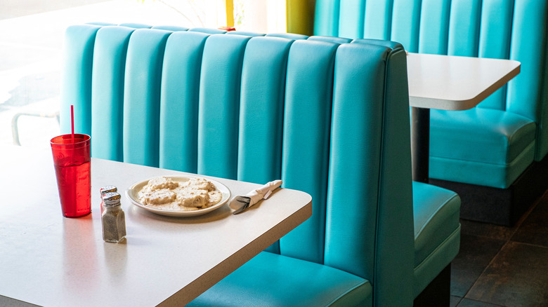 Plate of biscuits and gravy on a table in a diner booth