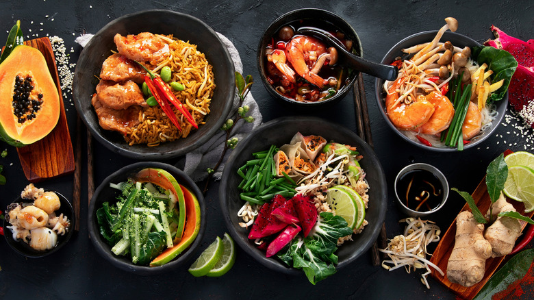 Assorted Thai dishes and ingredients on black table