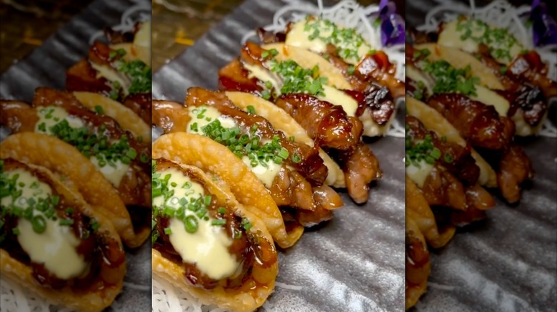 Mirrored image of Nobu Malibu's wagyu tacos on grey rippled plate