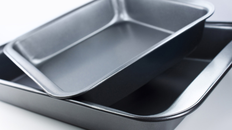 Two metal roasting pans sit on a table