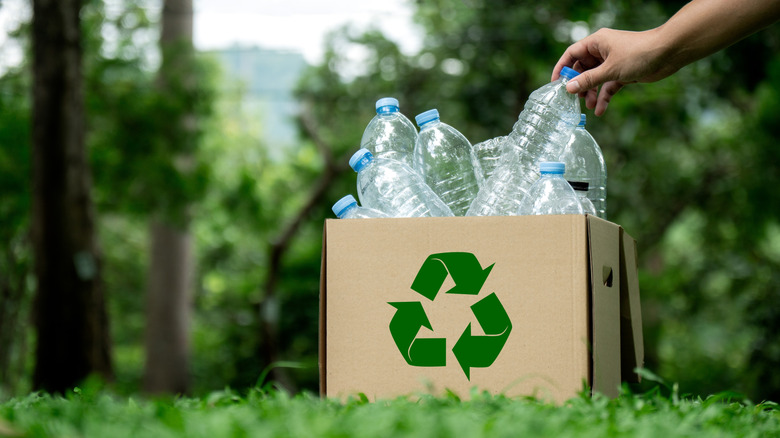 Cardboard box of plastic bottles with recycling symbol