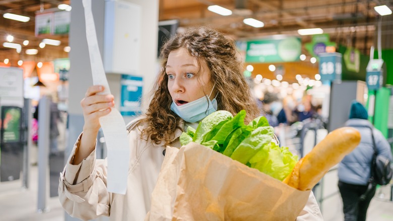 woman holding receipt in supermarket
