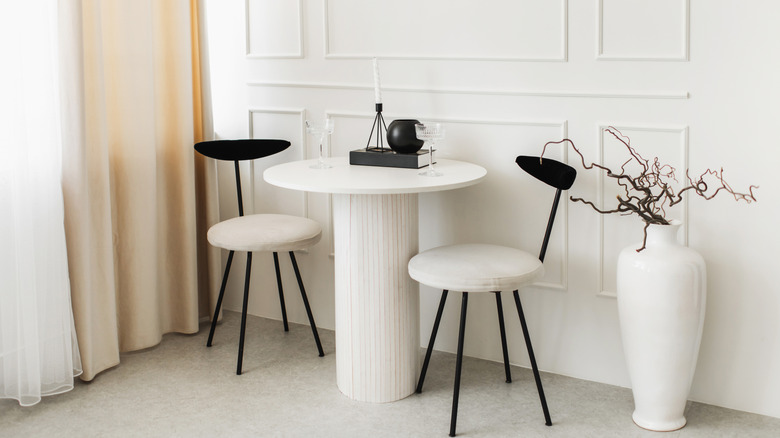 Elegant breakfast nook with white and black chairs around a round table