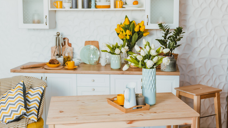 Wooden tabletop with attractive decor, including vases, a jug, cup, and candles