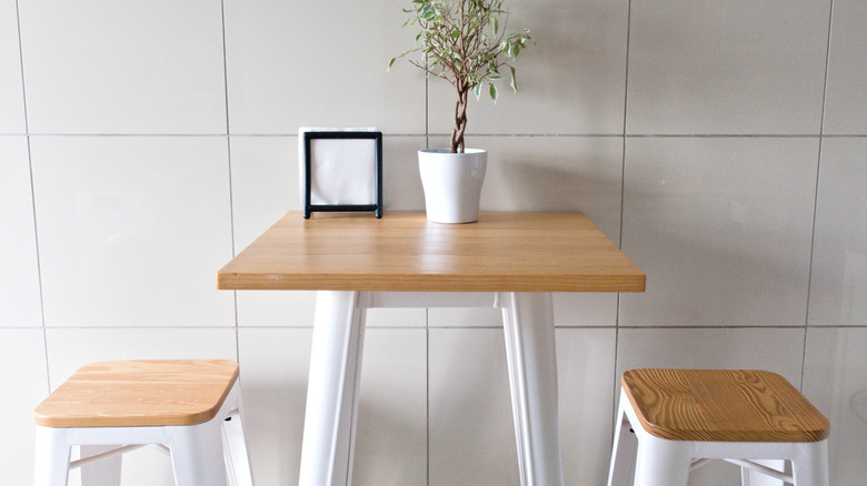 Minimalist breakfast nook with two stools against a table