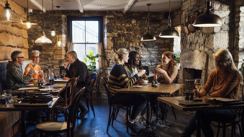 Restaurant interior with various diner groups occupying three tables