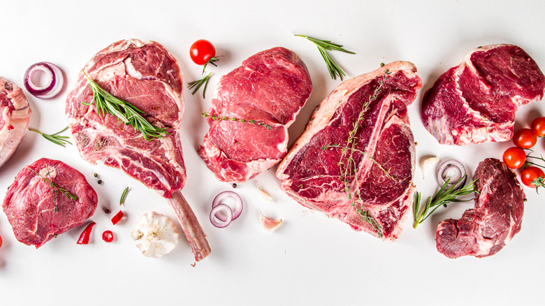 Raw steaks against white background