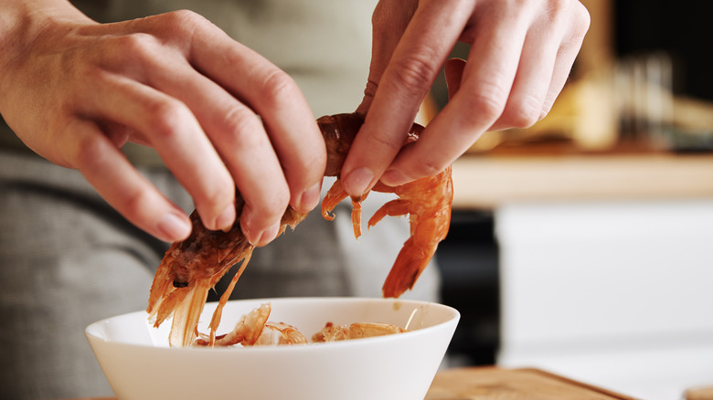 Hands holding whole shrimp