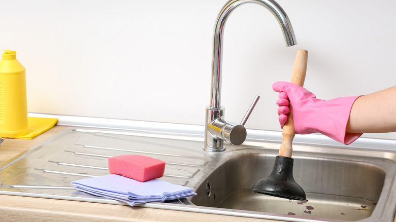 Home cook plunging a clogged kitchen sink