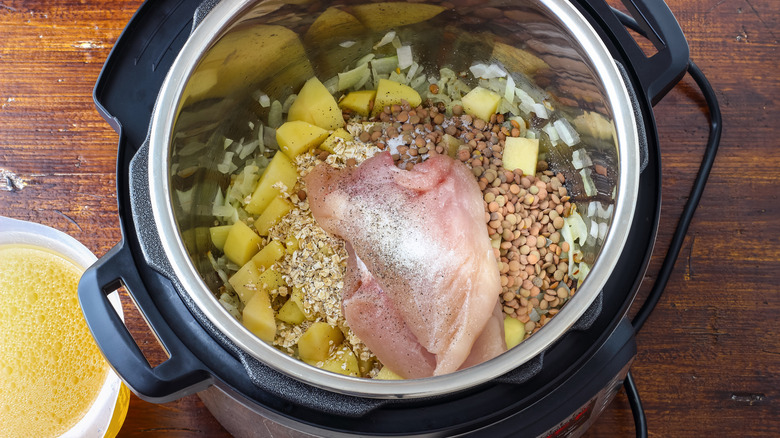 Raw chicken and ingredients in an open Instant Pot