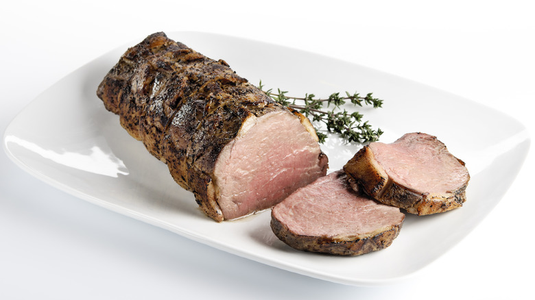roast beef slices on white dish with herbs