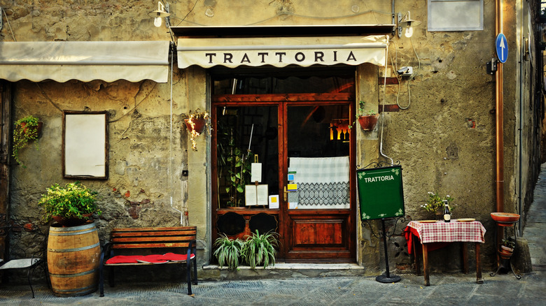 An old restaurant door that reads "Trattoria"