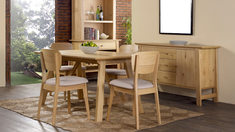 View of a simple dining room with natural wood and neutral rug