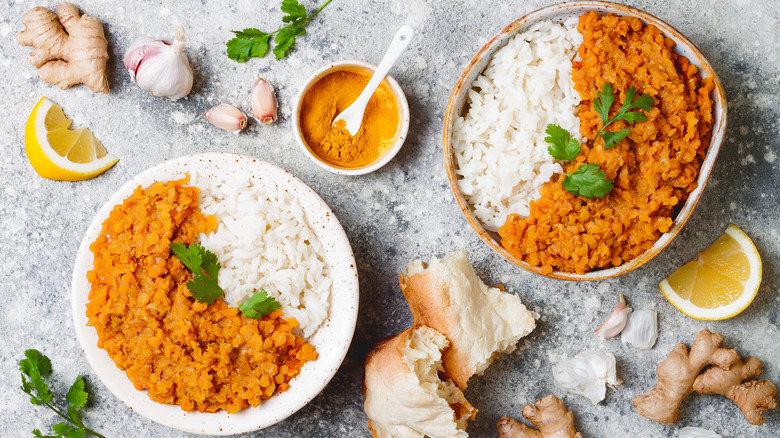 Overhead view of two plates of Indian lentil daal with turmeric