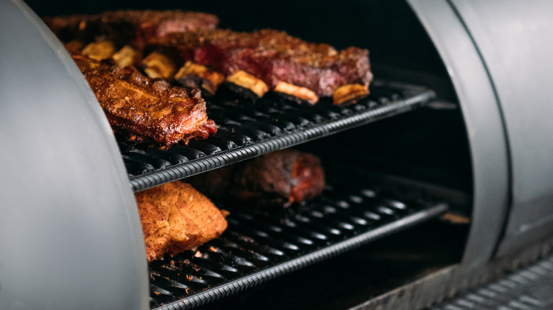A rack of ribs cooking in a smoker