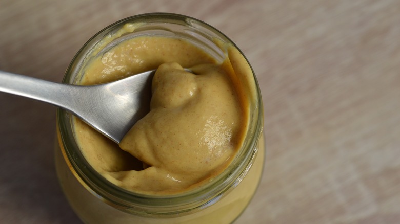 Spoon in glass mustard jar