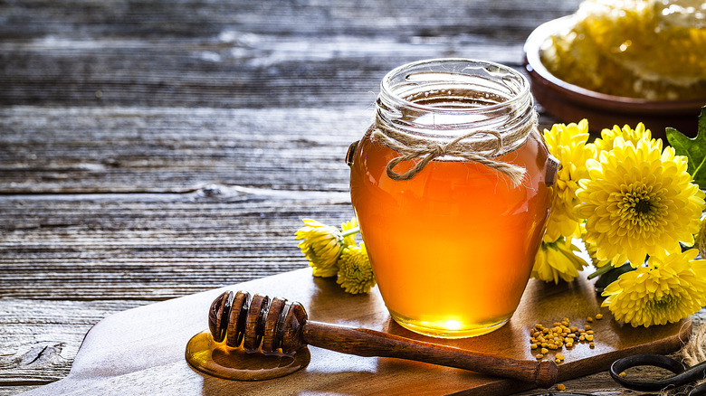 jar of honey on wooden serving board