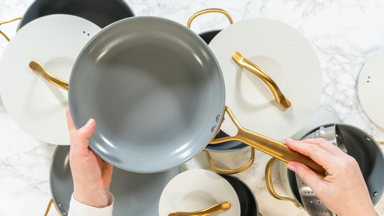 Top view of beige and gray cookware with golden hardware