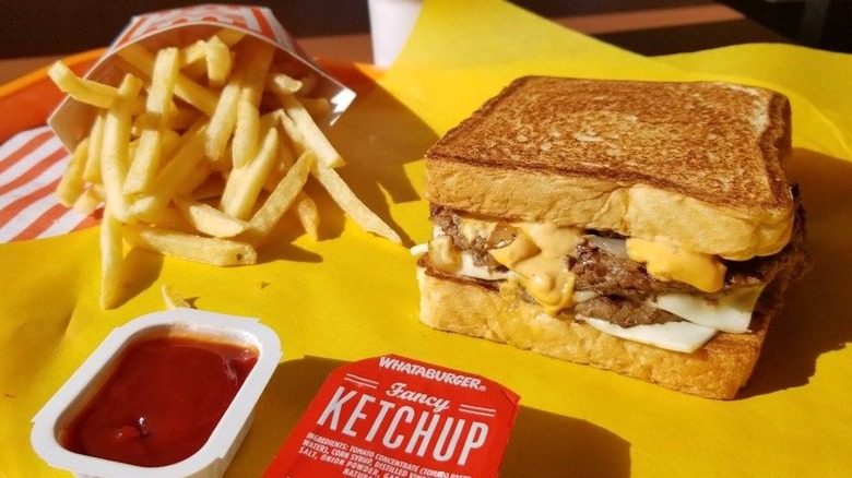 View of Whataburger patty melt, fries, and a drink on a table
