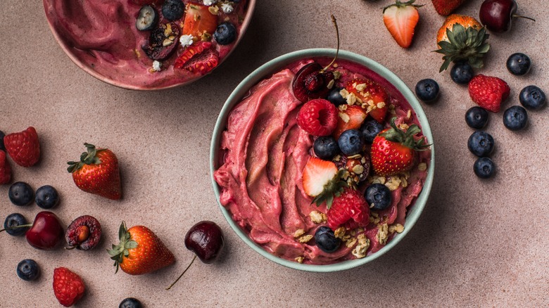 Two açai bowls with berries