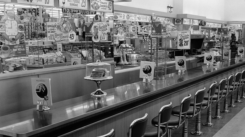 A black-and-white photograph of the counter of an empty luncheonette