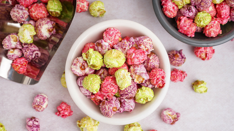 colorful popcorn in white bowl and silver scooper