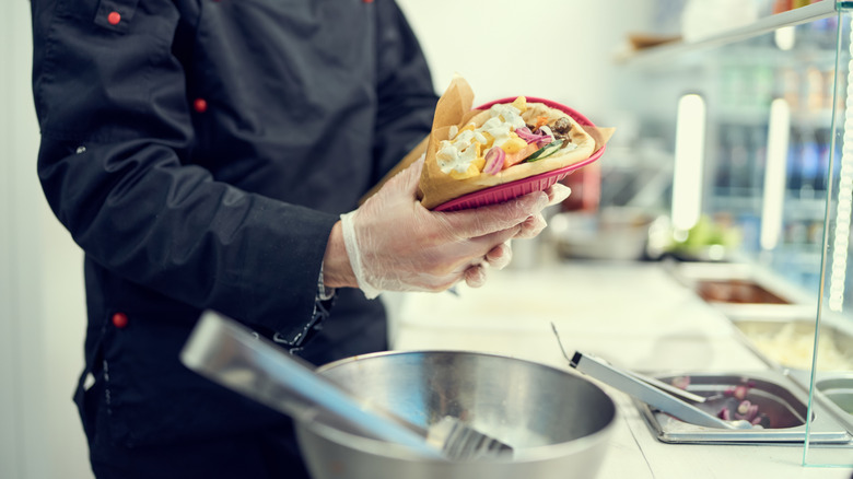 cook preparing pizza in kitchen of restaurant