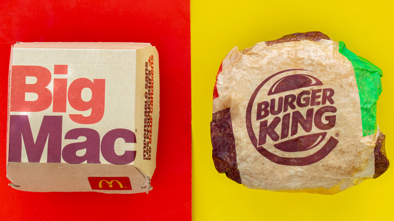 Big Mac in package on red screen versus Whopper in wrapper on yellow screen