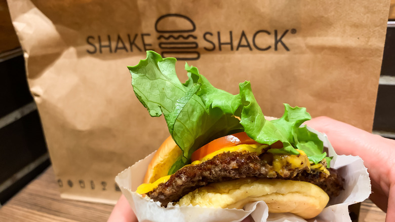 Hands holding Shake Shack cheeseburger