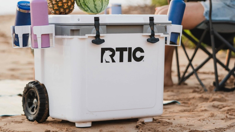 Hard-sided RTIC cooler on beach filled with cans and ice