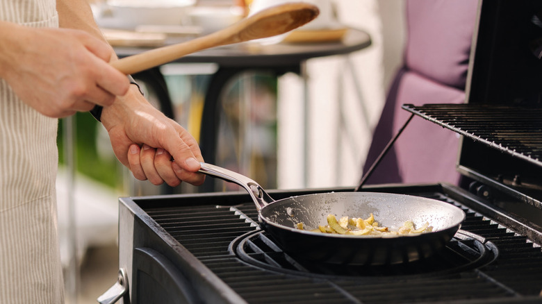 A chef frying in a carbon steel pan