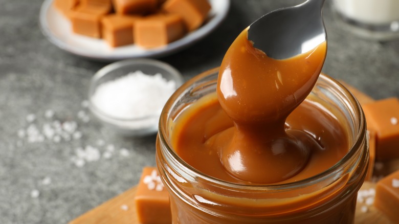 Caramel sauce in jar with spoon