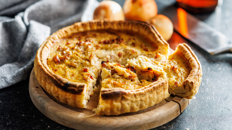 Closeup of vegetable quiche on a wooden serving board