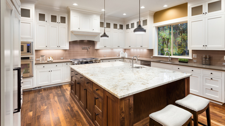 large kitchen with a granite slab island in the middle