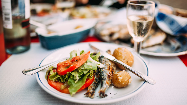 A Portuguese meal of fresh tomato, grilled fish, and potatoes