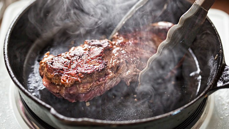 grillling steak in cast iron pan