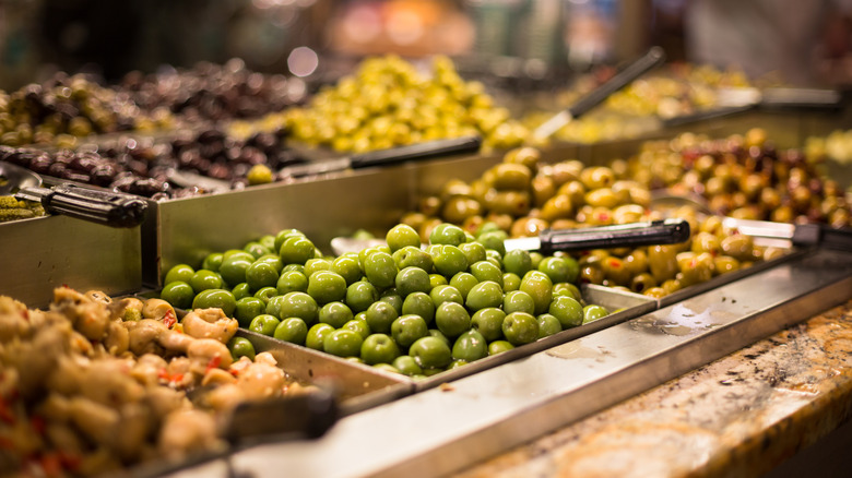 Variety of olives on display at a grocery store olive bar