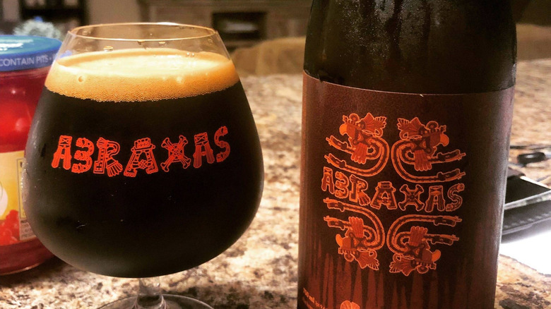 a glass of Arbraxas beer beside a bottle of the same