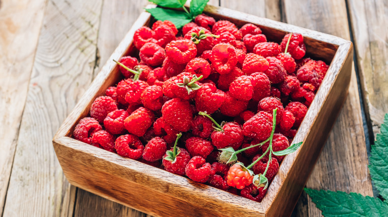 wooden box full of a raspberry harvest