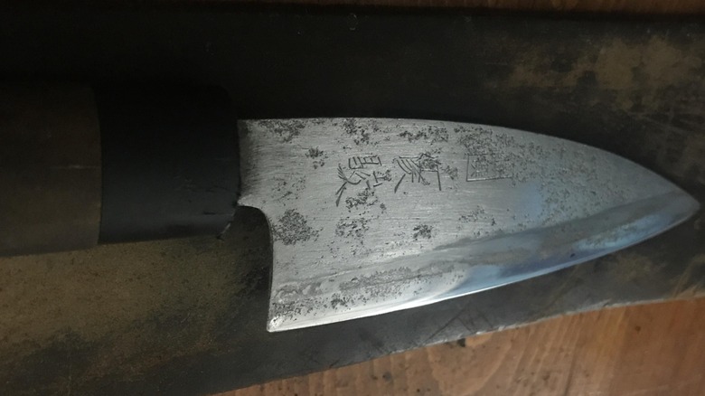 Old knife with significant pitting damage on the surface