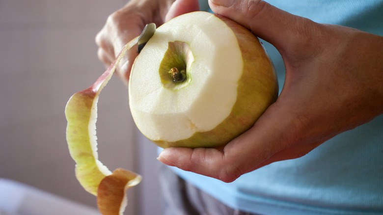 person peeling apple