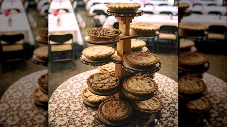 Wooden tower holding multiple pies on table