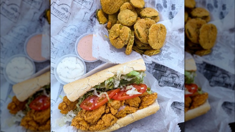 Half a fried fish po'boy and fried pickles on Parkway Bakery-branded paper