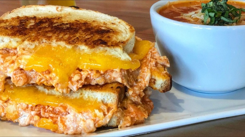 Grilled cheese on a platter next to a bowl of soup